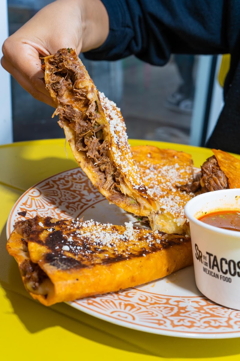 Hand holding a cheesy taco